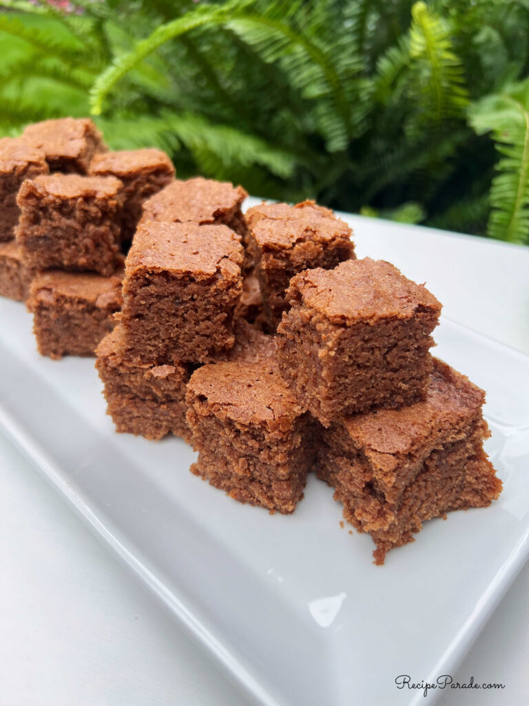 Brownie squares stacked on a platter.