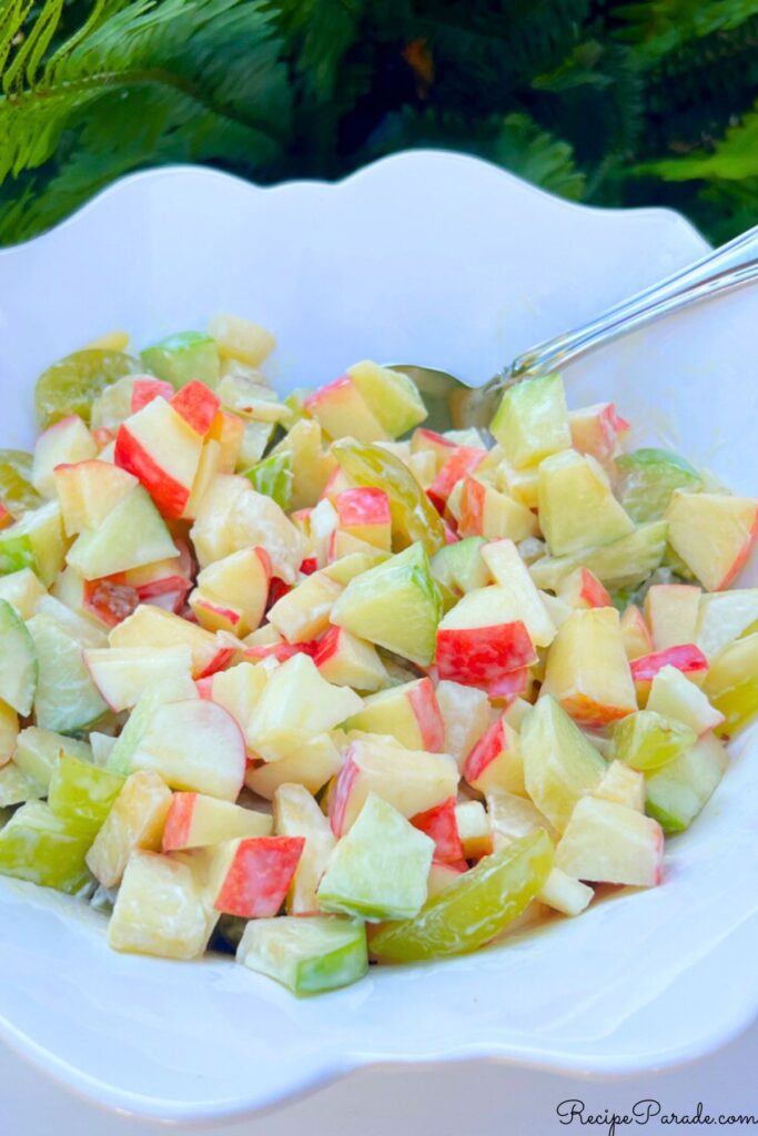 Colorful apple salad in a white bowl.