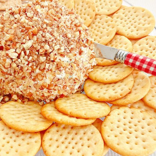 Pineapple cream cheese ball on a platter with crackers.