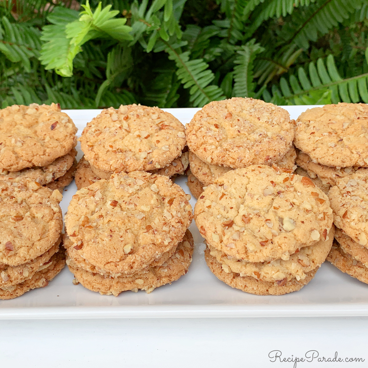 Stacks of butter pecan cookies on a cake platter.