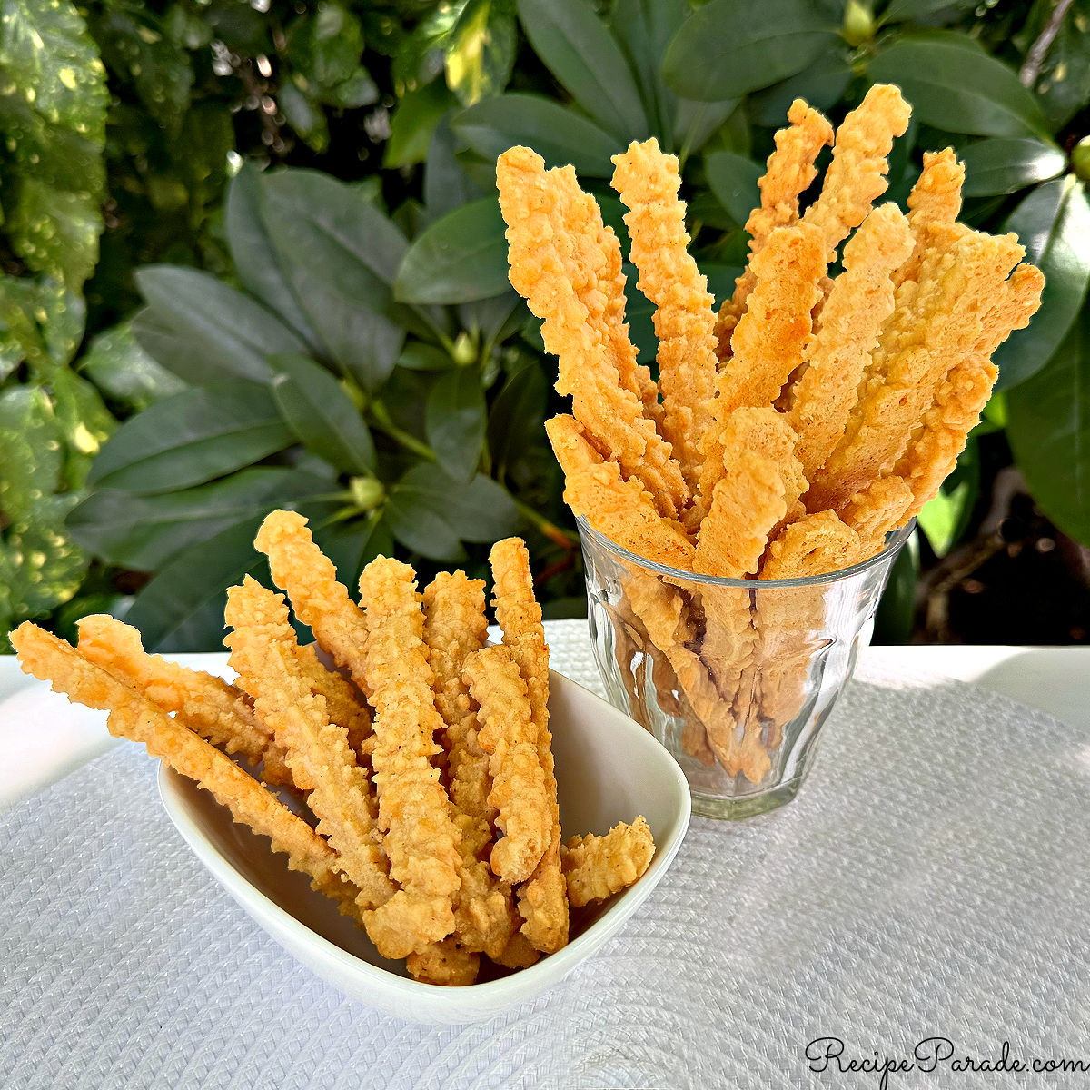 Cheese Straws in a glass and bowl.