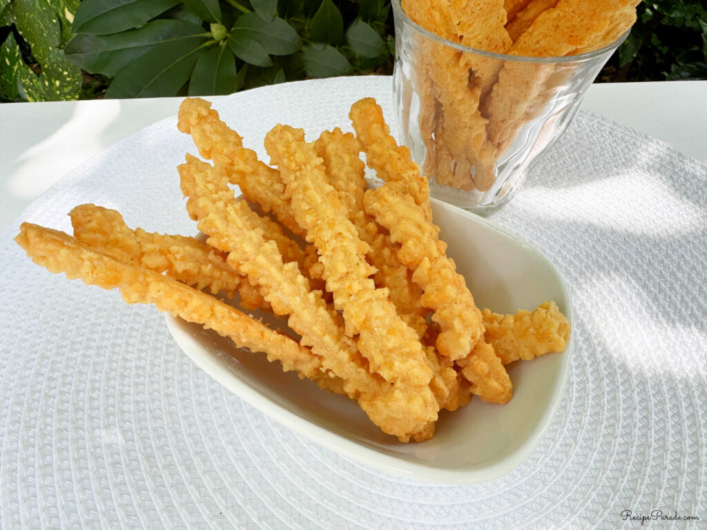 Cheese straws in a bowl and glass.