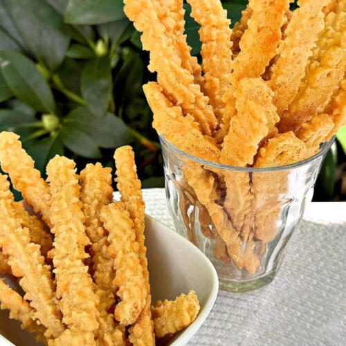 Cheese Straws in glass and bowl.