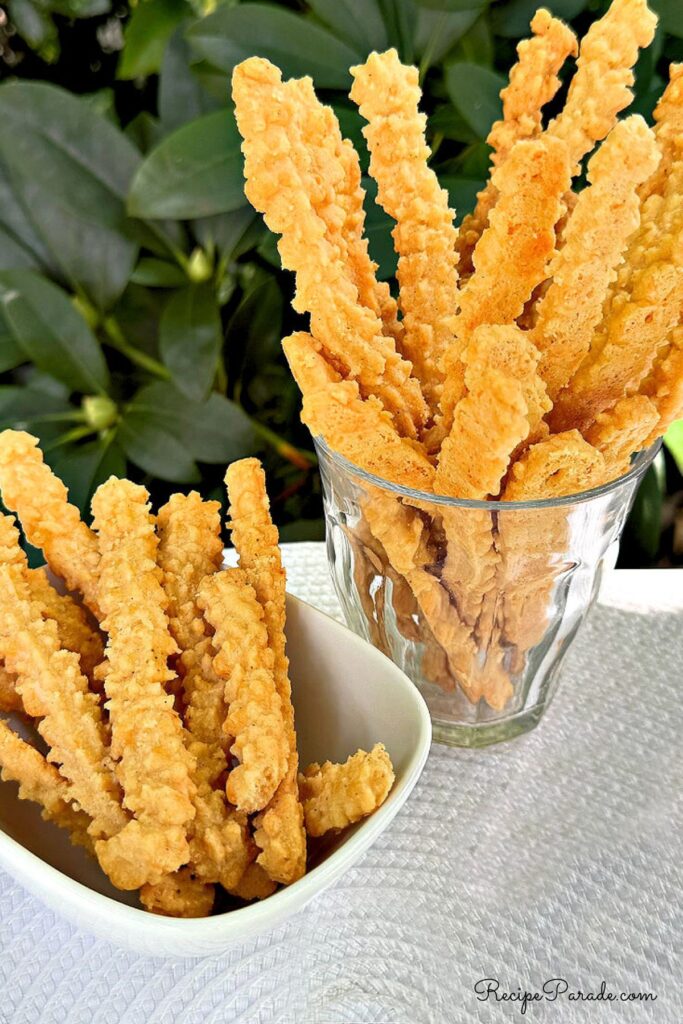 Cheese Straws in glass and bowl.