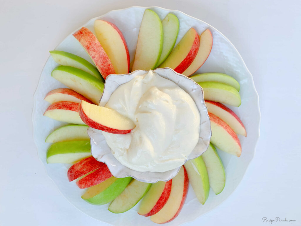Sliced apples arranged around a bowl of apple dip.