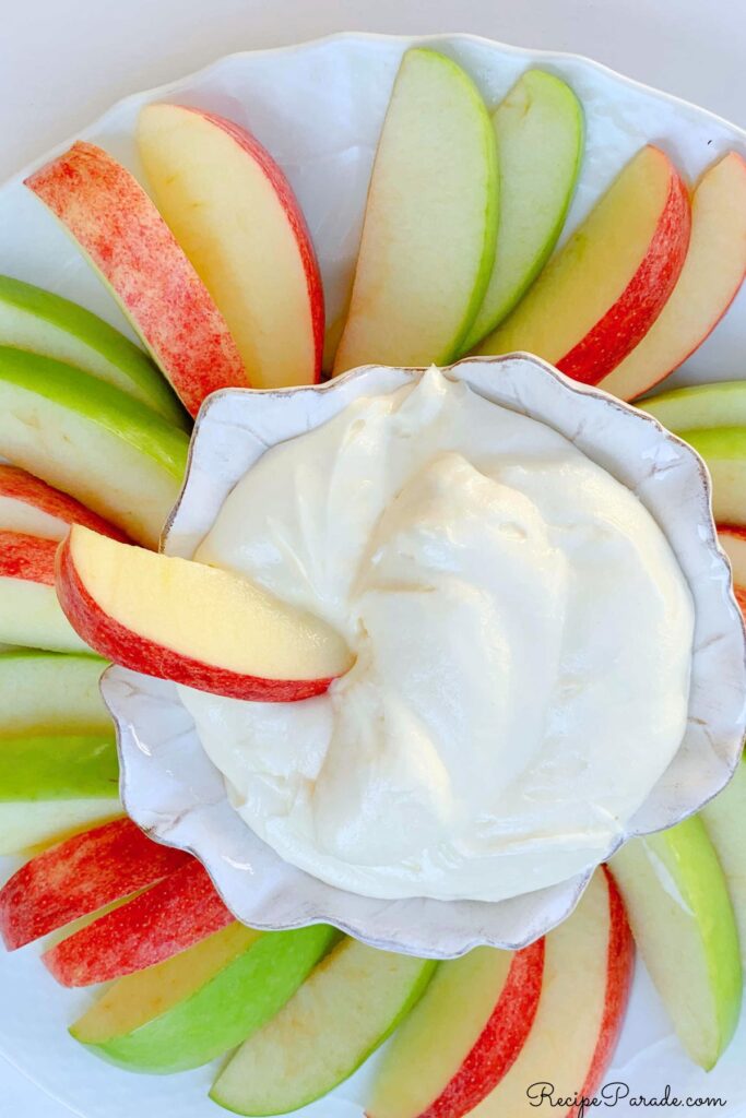 Platter of sliced apples with a bowl of apple dip.