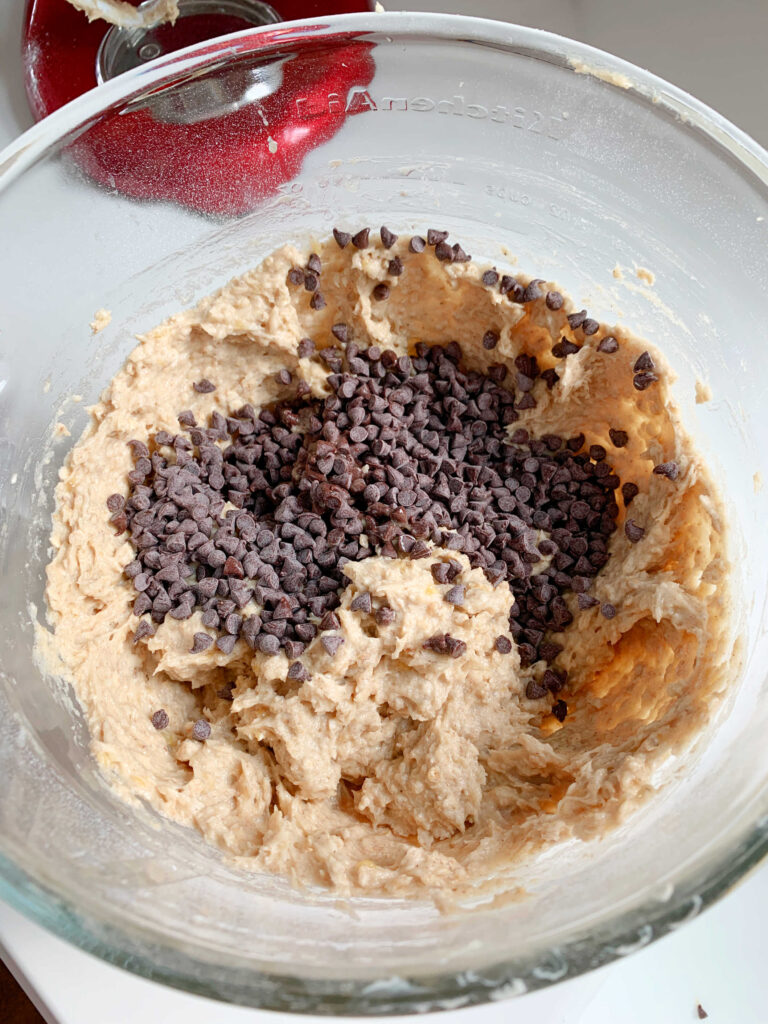 Adding nuts and chocolate chips to the cookie batter.