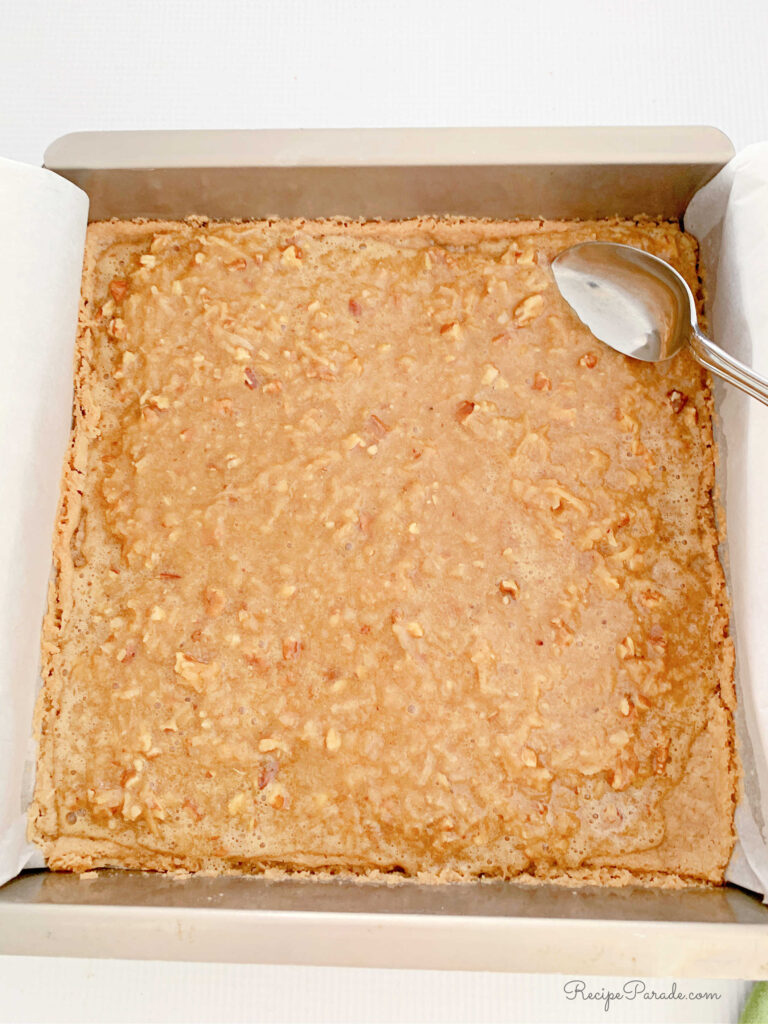 Spreading filling over the shortbread crust.