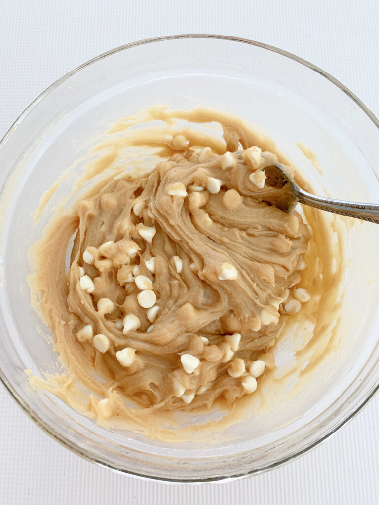 Stirring white chocolate chips into batter for blondies.