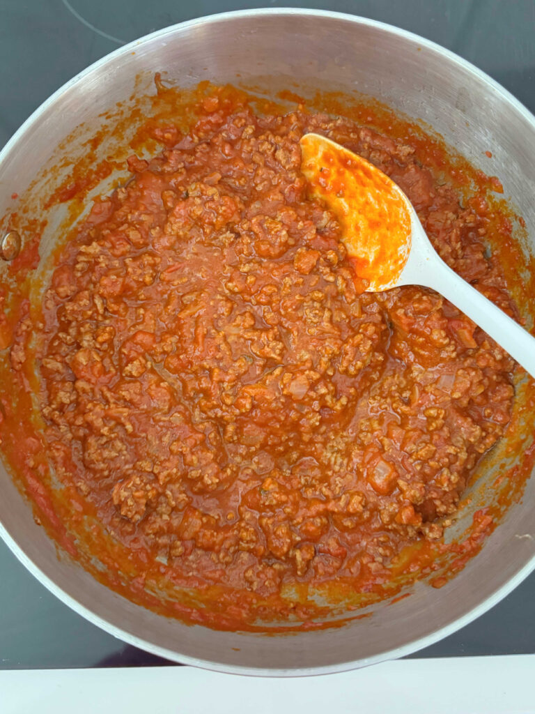 Ground beef and sauce in a pan.