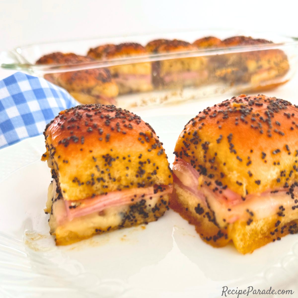Two ham and cheese sliders on a plate.