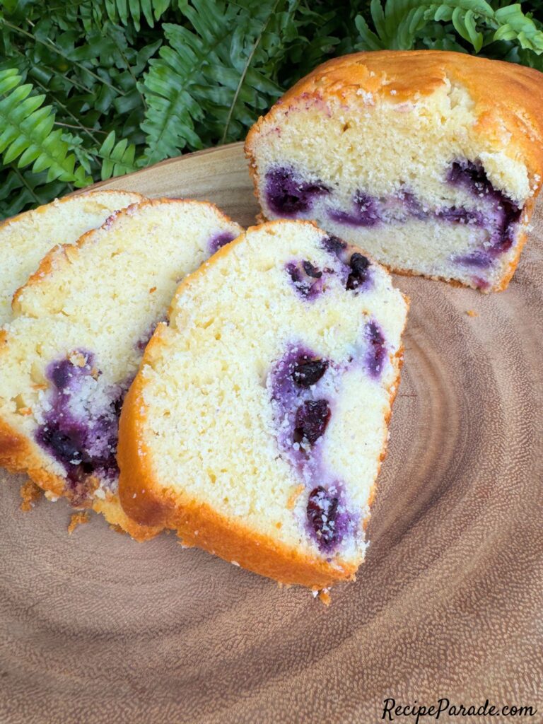 Lemon Blueberry Bread, sliced, on a cake pedestal.