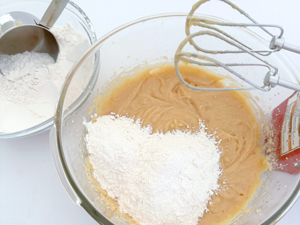 Mixing flour into batter for Oatmeal Coconut Cookies.