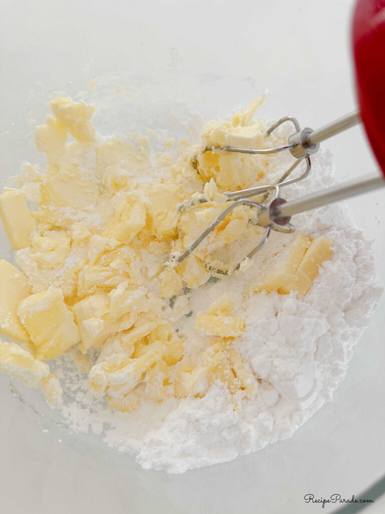 Mixing the softened butter and confectioners sugar.