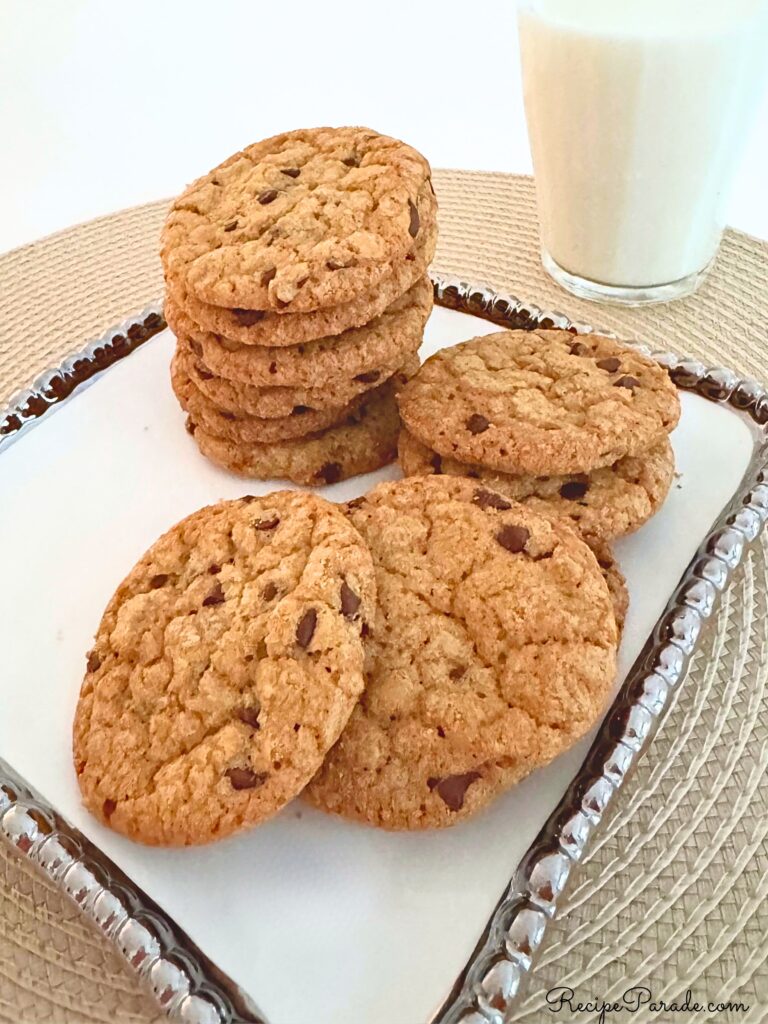 Chewy Chocolate Chip Cookies on a tray with milk.